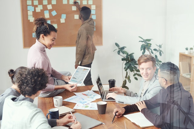 group%20of%20colleagues%20looking%20over%20document%20and%20organizing%20things%20on%20a%20board